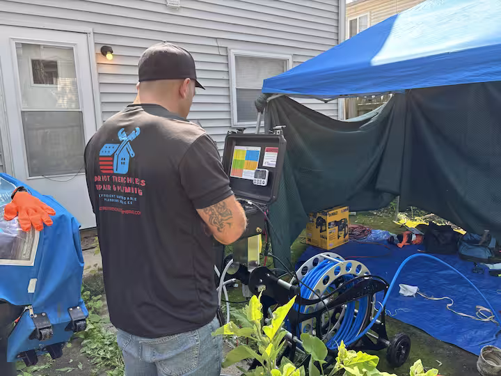 Patriot Trenchless Plumbing technician preparing equipment at a trenchless sewer repair job site in the western Chicago suburbs