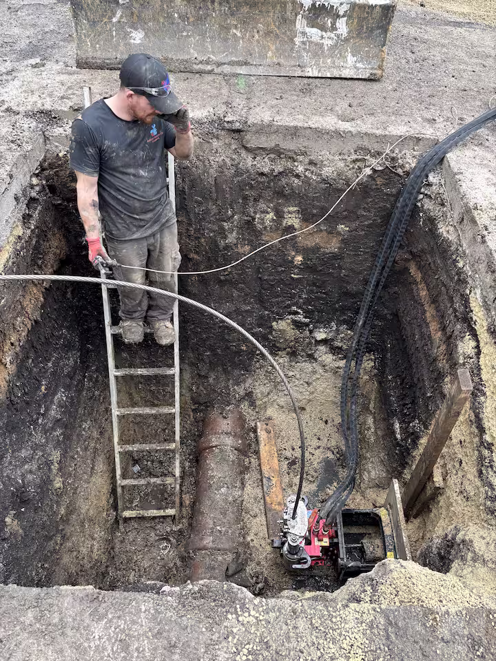 Pipe bursting method pulling a new sewer line underground during a trenchless repair in Montgomery, Illinois 