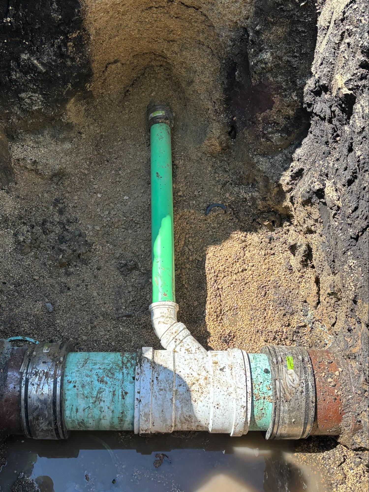 New green HDPE sewer pipe connected to the existing line during a Patriot Trenchless pipe bursting job in Chicagoland.
