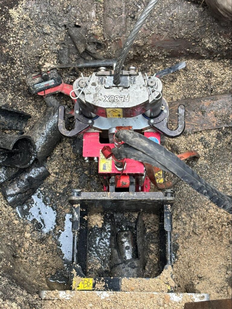 Hydraulic pipe bursting head pulling new HDPE pipe through an old sewer line on a Fox Valley job.