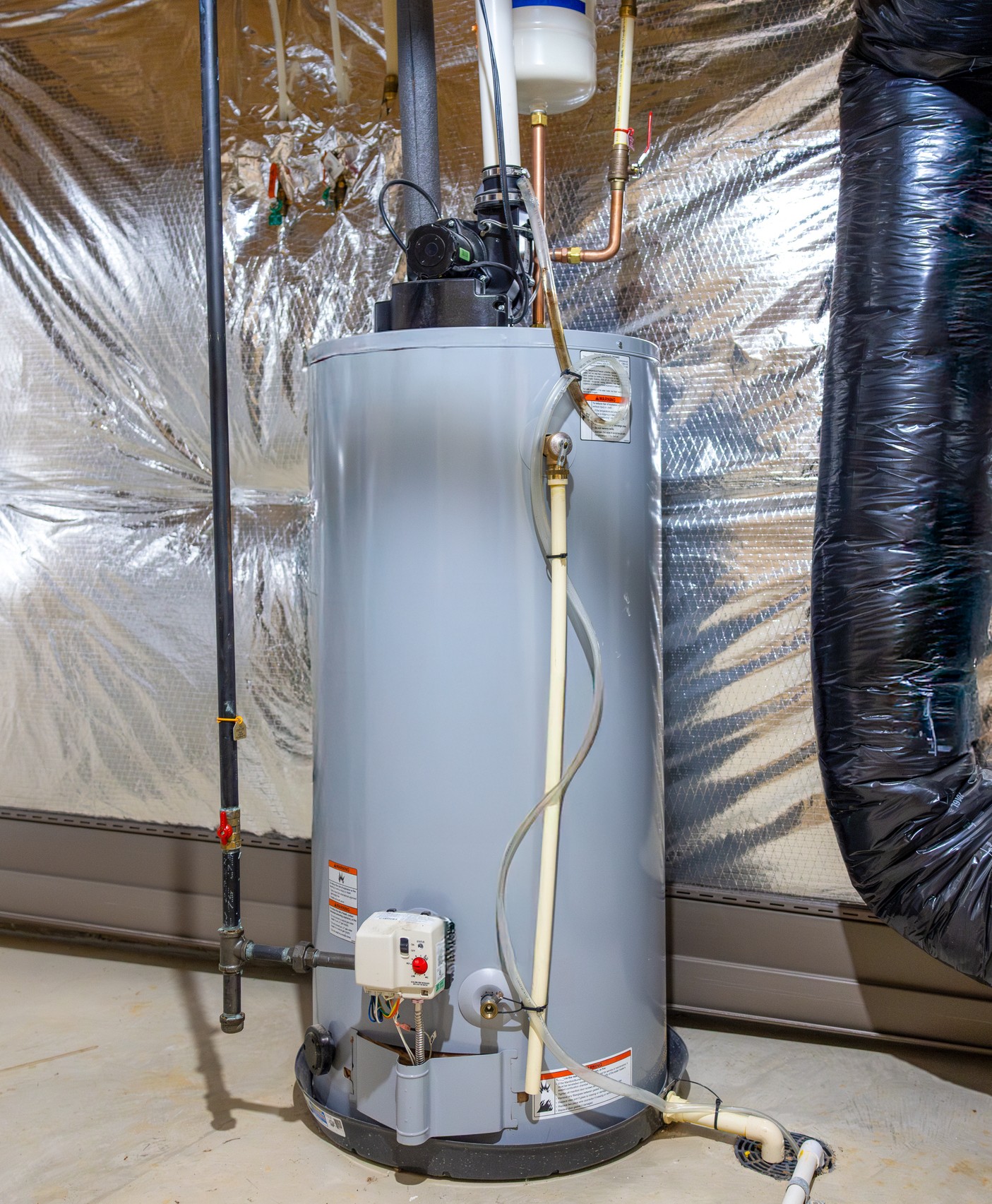 Gas water heater installation with expansion tank and copper supply lines in an Illinois basement.