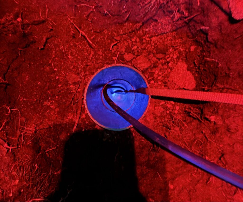 Resin-saturated CIPP liner fed into an existing sewer access point during trenchless sewer lining