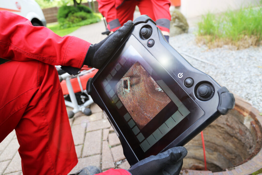 Sewer camera inspection monitor showing the inside of a damaged sewer line